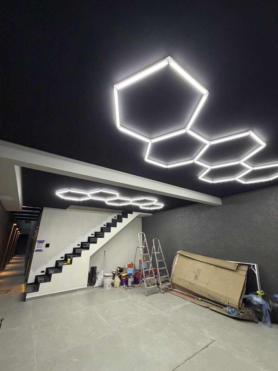 Iluminação LED hexagonal instalada em teto preto pela TM Soluções — vista 1