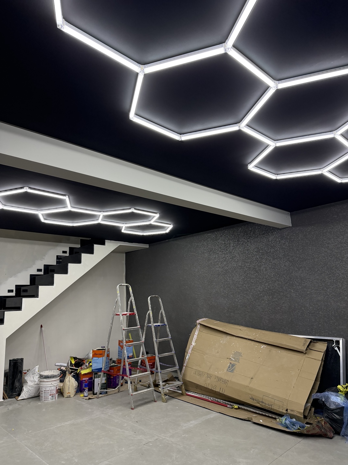 Iluminação LED hexagonal instalada em teto preto pela TM Soluções — vista 2