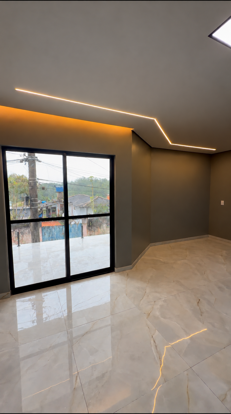 Iluminação linear embutida no teto e sanca com luz quente em ambiente da TM Soluções